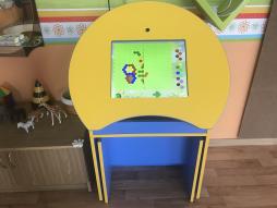 Интерактивный стол-парта, Смарт-доска. Дети могут выполнять различные интерактивные задания, конструировать, рисовать.